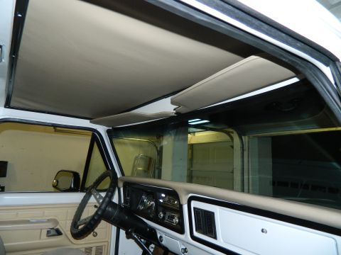 1979 Ford Bronco - The interior of a vehicle is shown, including the dashboard, steering wheel, and headliner.