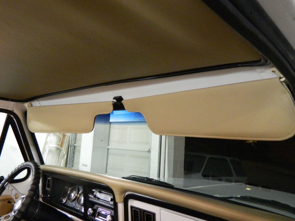 Tan interior of a 1978 Ford Bronco with sun visors and dashboard visible
