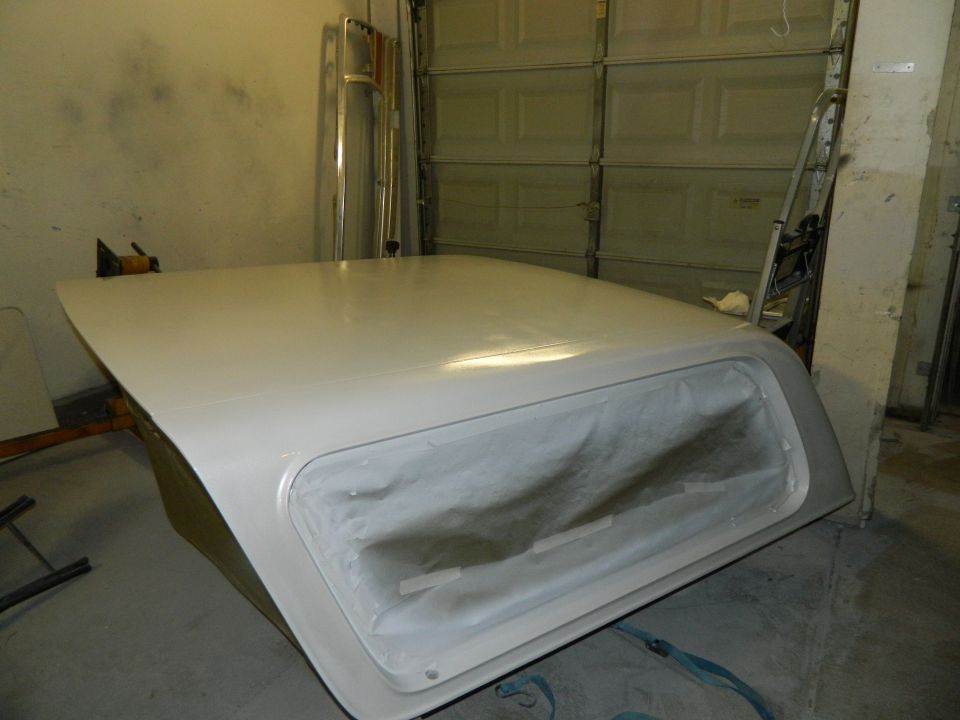 Ford Bronco hardtop with window opening covered in plastic, in a garage