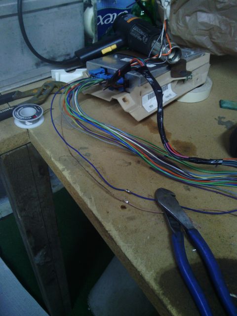 1978 Ford Bronco - An electronic control unit and a complex wiring harness are laid out on a workbench, ready for modification or repair.