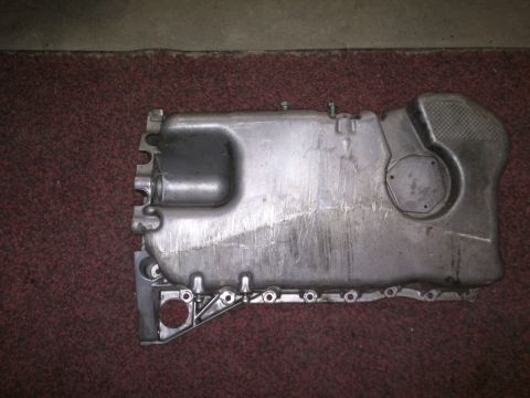 2002 Volkswagen Jetta - A metal oil pan, likely from an engine, is shown from a top-down perspective on a textured surface.