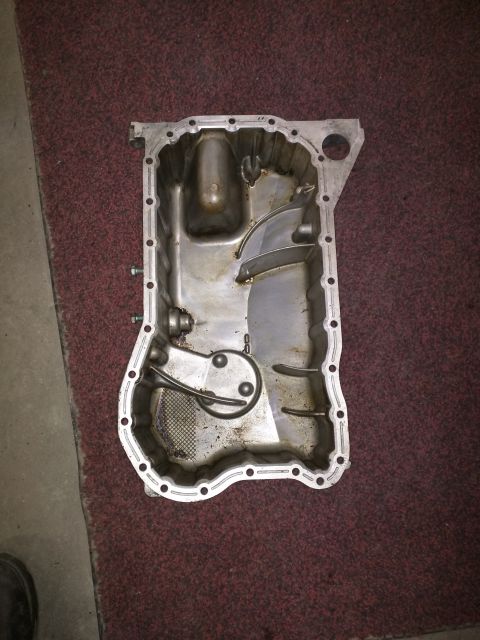 2002 Volkswagen Jetta - This is an oil pan with internal baffles and an oil pickup screen, likely removed from an engine for service or replacement.