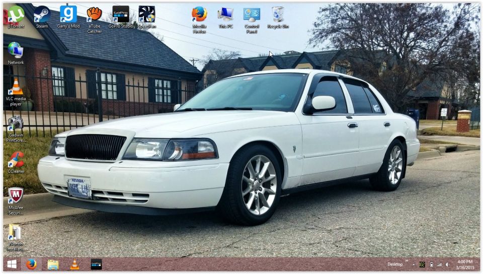 White 2000 Mercury Grand Marquis parked on street, front quarter view. Desktop icons visible