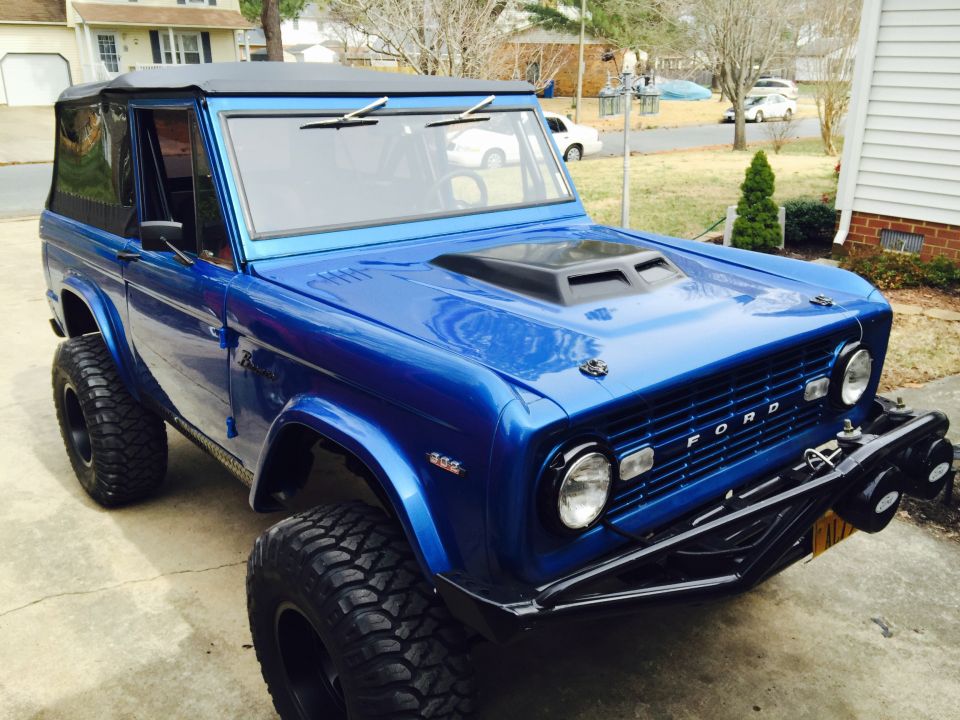 Blue 1974 Ford Bronco with aftermarket hood scoop and soft top