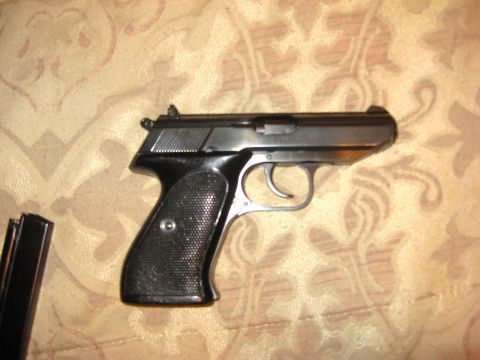 1976 Dodge Power Ram - A pistol and its magazine are shown on a patterned fabric background.