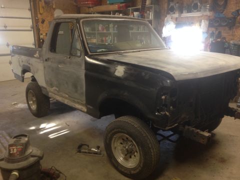 1992 Ford Bronco - This Ford truck is undergoing bodywork in a garage, showing its unfinished state.