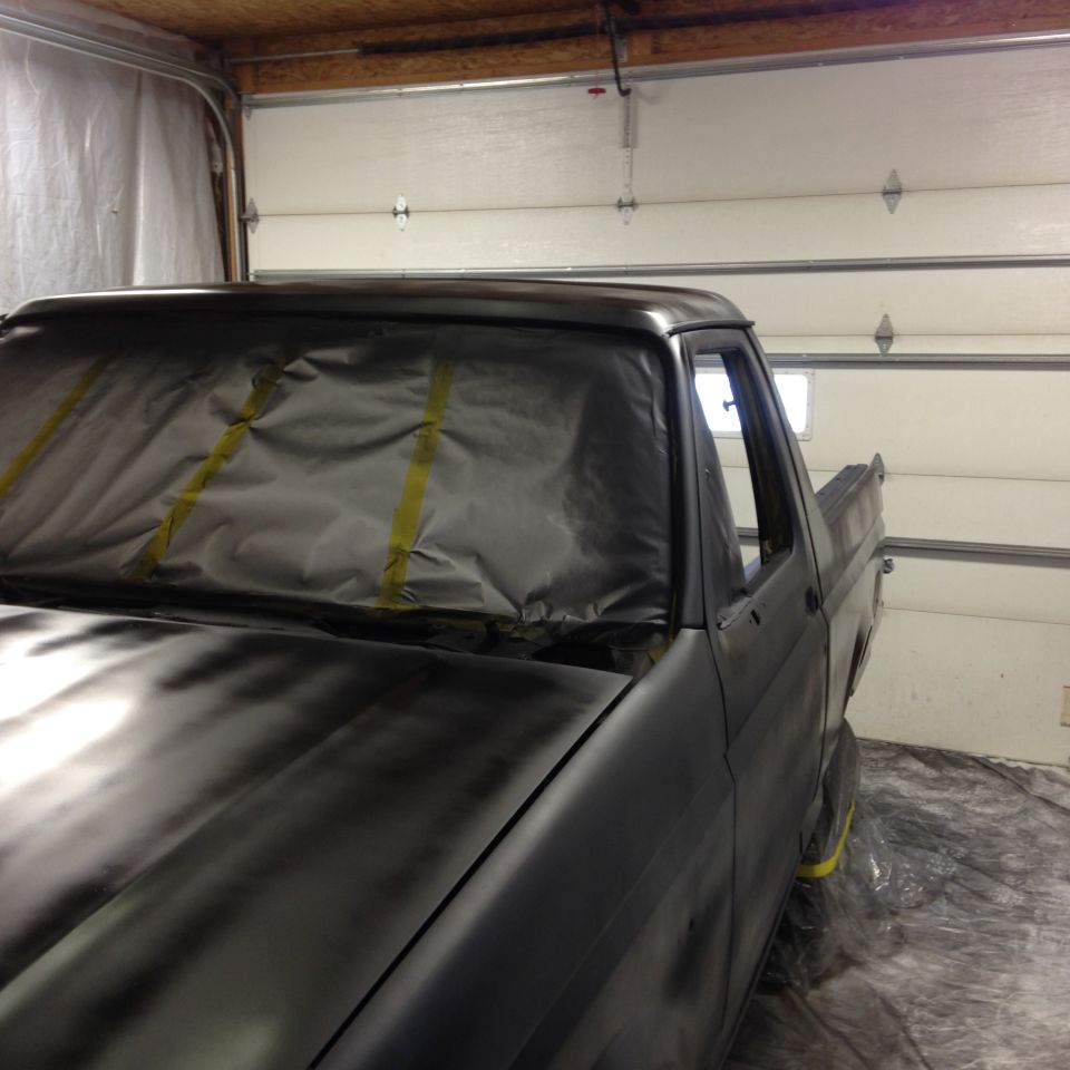 Gray truck cab with masked windshield, side view of door and bed