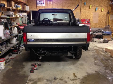1992 Ford Bronco - Rear view of a 1992 Ford Bronco in a garage setting, with tools and storage visible.