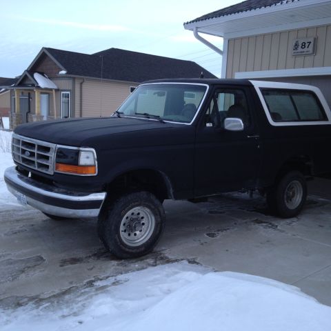 1992 Ford Bronco - A black 1992 Ford Bronco is parked in a driveway during winter.