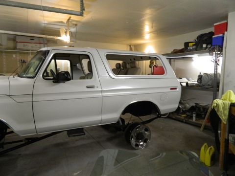 1979 Ford Bronco - Side view of a white Ford Bronco, possibly a 1978 model, undergoing work in a garage.