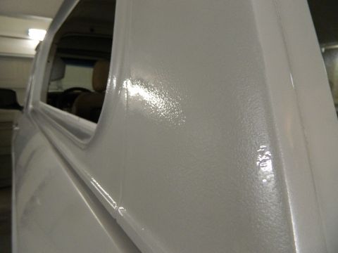 1979 Ford Bronco - The textured white paint on the side of a vehicle is shown, with a glimpse of the interior through the window.