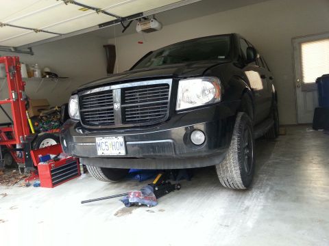 2007 Dodge Durango - 2007 Dodge Durango is lifted on jacks inside a garage for maintenance.