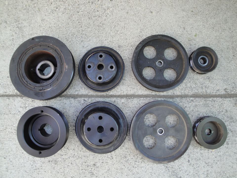 Assortment of black metal pulleys on a concrete surface