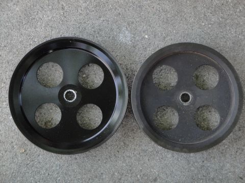 1995 Ford Taurus - Comparison of a new pulley and a used pulley, both four circular cutouts and a central spline.