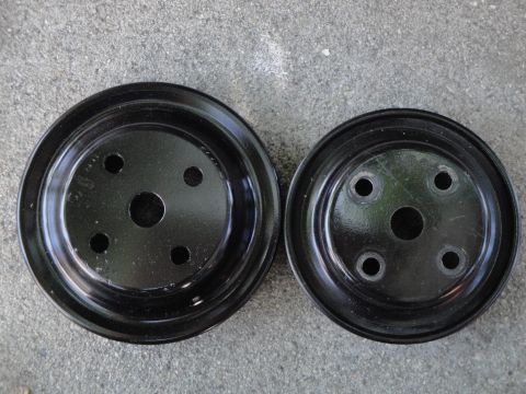 1995 Ford Taurus - Two automotive pulleys shown side-by-side on a gray concrete background.