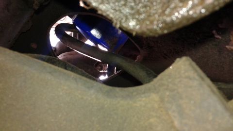 1988 Ford Bronco - A close-up view shows a blue shock absorber and a dark hose, likely part of a vehicle's suspension system.
