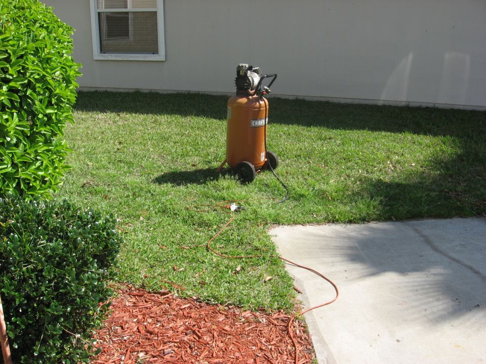 Orange Craftsman oilless air compressor on grass