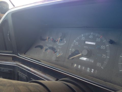 1987 Ford Bronco - The interior of a 1987 Ford Bronco shows dusty gauges and the gear selector.