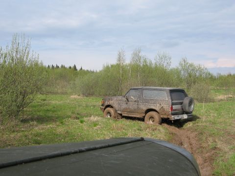 1987 Ford Bronco - This 1987 Ford Bronco is stuck in the mud, with its rear tire prominently displayed.
