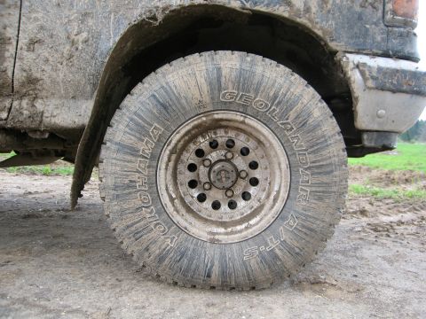 1987 Ford Bronco - A close-up shot of a muddy tire and fender well of an off-road vehicle.