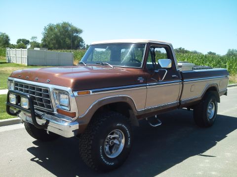 1979 Ford F-150 - This two-tone Ford pickup truck is equipped with large all-terrain tires and a front brush guard.