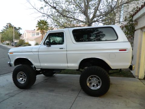 1979 Ford Bronco - This lifted 1978 Ford Bronco is parked on a paved surface in front of a house.