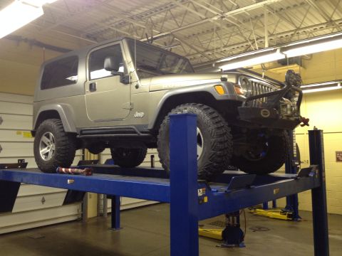 2005 Jeep Wrangler - A silver 2005 Jeep Wrangler is shown on a hydraulic lift in a garage setting.
