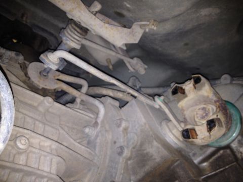 2005 Jeep Wrangler - Close-up of vehicle transmission and linkage, likely part of a repair or maintenance task.