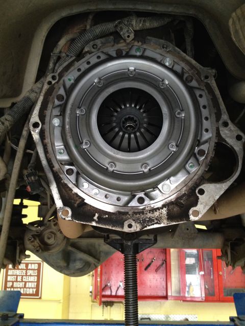 2005 Jeep Wrangler - Close-up view of a vehicle's clutch assembly and transmission bell housing, supported by a jack stand.