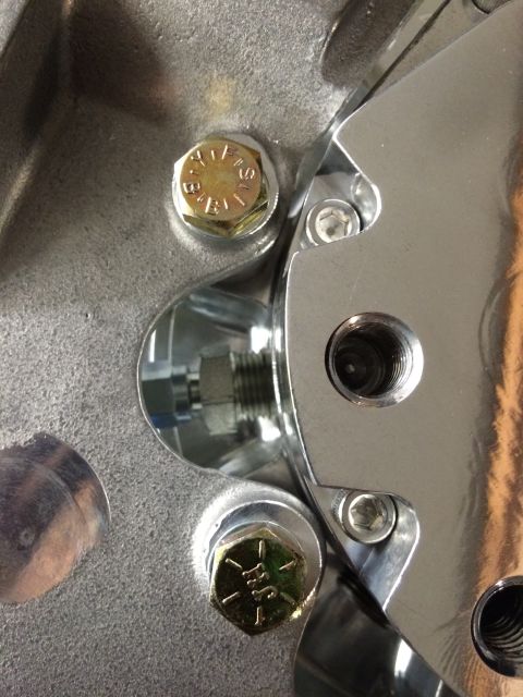 2003 Mercury Marauder - Detail of a mechanical component, showing fasteners and threaded ports. Text is visible on one bolt head.