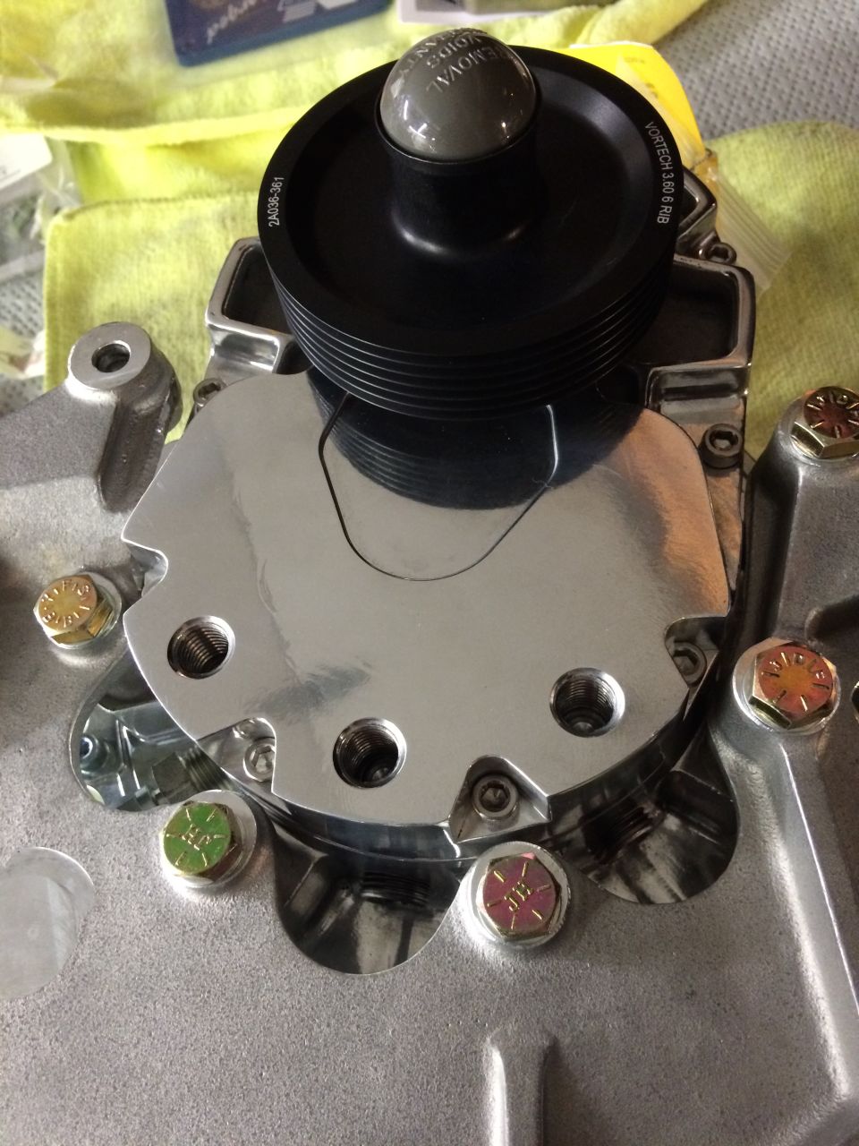 Vortech supercharger pulley with grey knob on polished aluminum housing, secured by bolts