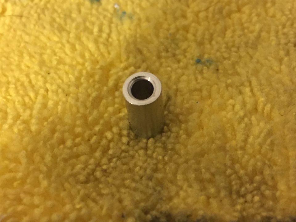 Metal spacer on yellow textured cloth