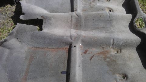 1994 Ford Bronco - Car carpet removed from vehicle, showing signs of wear and rust.