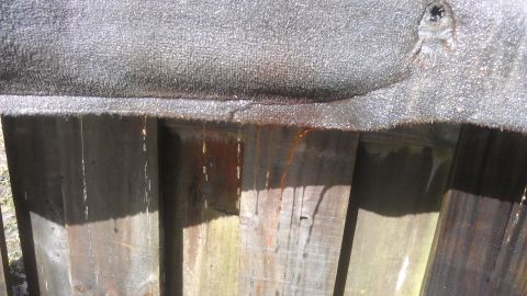 1994 Ford Bronco - Liquid streaks down wooden fence posts from an overhead textured surface.