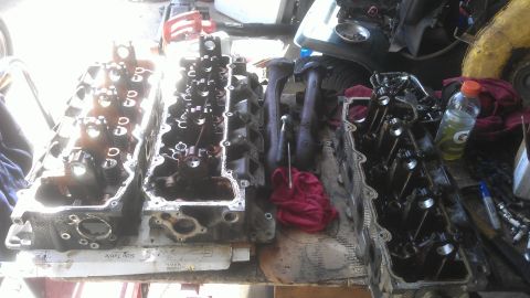 1994 Ford Bronco - Disassembled engine components are laid out on a workbench, suggesting a repair or rebuild process.