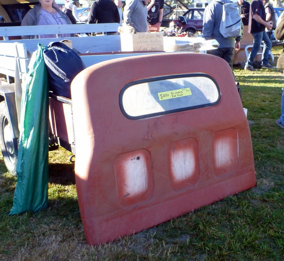 Red tailgate with window and three indentations, yellow price tag on window
