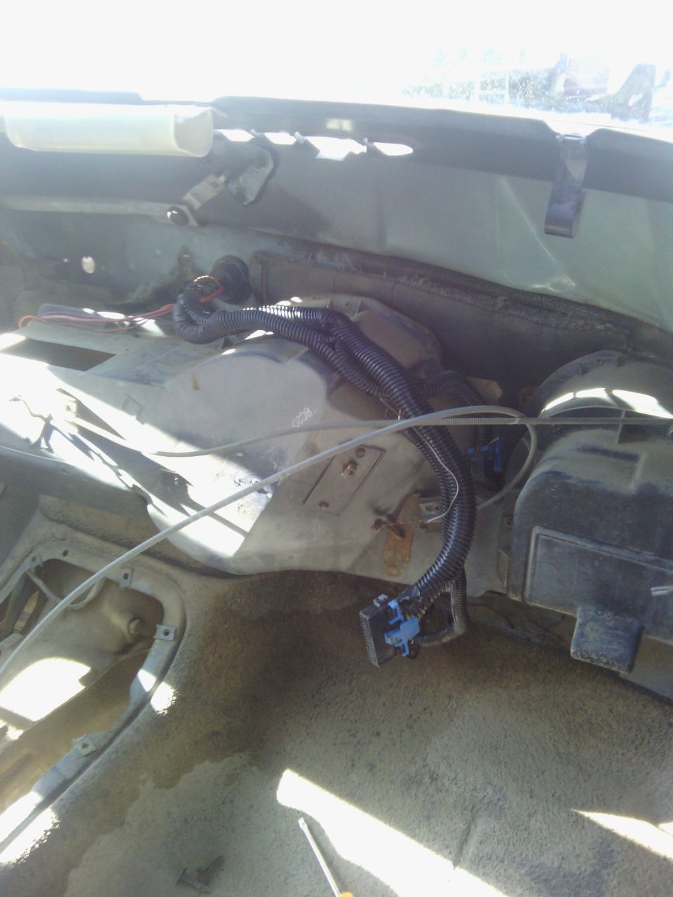 Close-up of vehicle interior showing exposed wiring harness and dashboard components
