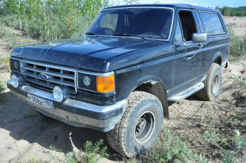 1987 Ford Bronco - This 1987 Ford Bronco is parked off-road with dirt and vegetation surrounding it.