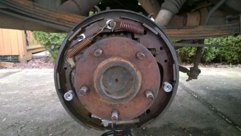 1994 Ford Bronco - Close-up of a vehicle's rear drum brake assembly, showing internal components and suspension linkage.
