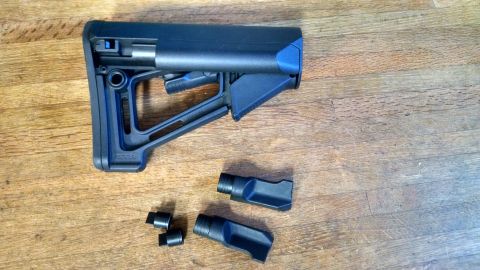 1996 Ford Bronco - Adjustable gun stock with blue accents and two separate attachments shown on a wooden surface.