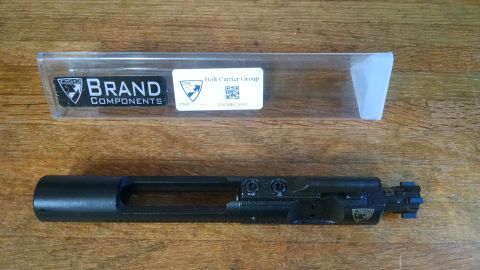 1996 Ford Bronco - Bolt carrier group with packaging on a wooden surface.