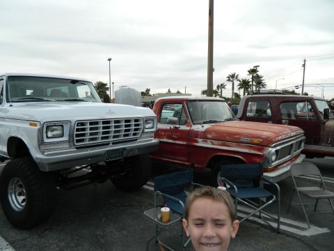 1979 Ford Bronco - Two Ford F-Series trucks, a white lifted model and a red pickup, are parked side-by-side.