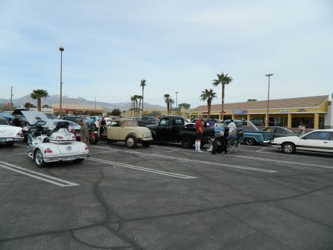 1979 Ford Bronco - A gathering of classic and modern vehicles in a parking lot, possibly a car show.