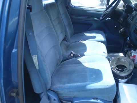 1979 Ford Bronco - Interior of a blue truck showing the front seats and dashboard area.