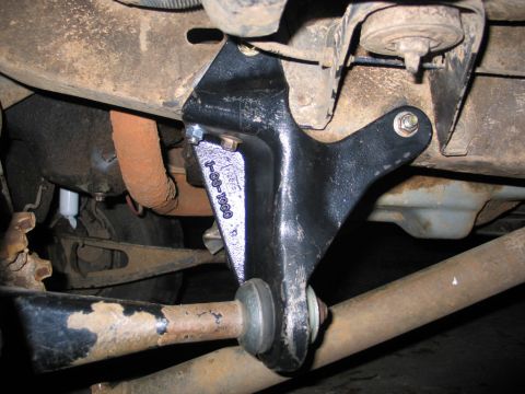 1995 Ford Bronco - A close-up view of a vehicle's undercarriage shows a black metal bracket, likely part of a suspension lift kit.