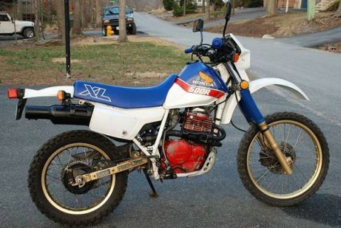 1966 Ford Bronco - White and blue Honda 600R motorcycle parked on pavement.