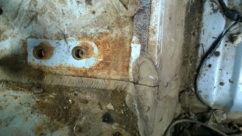 1994 Ford Bronco - This image shows a heavily rusted section of a vehicle's frame, likely from the undercarriage or interior structure.