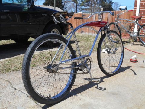 1994 Ford Bronco - A shiny cruiser bicycle is parked next to a black truck on a sunny day.