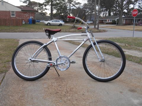 1994 Ford Bronco - Chrome cruiser bicycle with red accents parked on a concrete surface in a residential area.