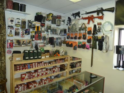 1992 Ford Mustang - A gun store interior displays firearms, ammunition, and accessories on pegboard walls and shelving units.